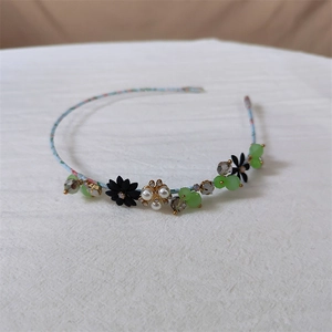 Detailweergave van de blauwe bloemen hoofdband met zwarte bloemen en kristallen kralen