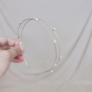 Dettaglio del cerchietto a doppio strato in oro rosa con cuore di cristallo e strass
