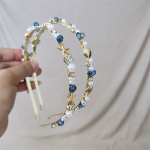 Detail of gold headband with blue and white pearls plus sea star and shell elements
