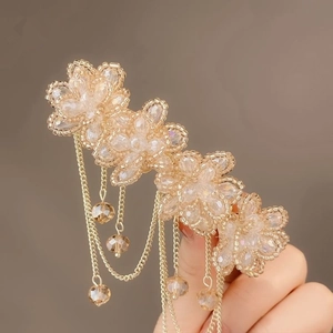 Detail of beaded floral hair clip featuring gold tassels and champagne crystal charms