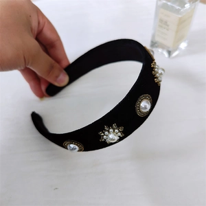 Serre-tête rétro français avec perles et strass sur velours noir, tenu à la main