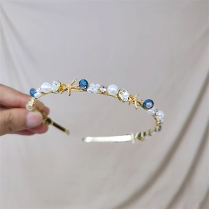 Detail of seashell headband with pearls, blue beads, and starfish on golden metal
