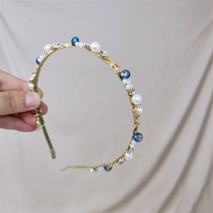 Close-up of golden headband with pearls, blue crystal beads and small starfish details