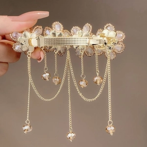 Detail of flower crystal tassel hair clip with gold chains and brown beads