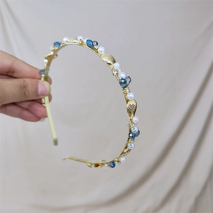 Elegant gold headband with blue crystals, white pearls, and golden sea shells for women