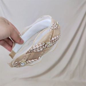 Detail of champagne woven headband with houndstooth fabric, mesh tulle and shiny rhinestones
