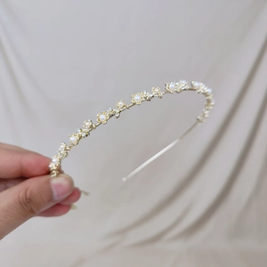 Détail d'un serre-tête doré fin orné de fleurs en perles et cristaux scintillants