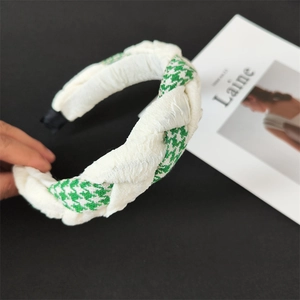 Detail of green and white houndstooth fabric headband with a stylish knotted design