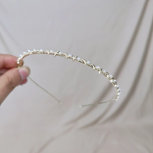 Detailed shot of gold metal headband with small pearls, stars and moon charms