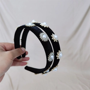 Détail du serre-tête en velours noir orné de perles et de strass en forme de tournesol