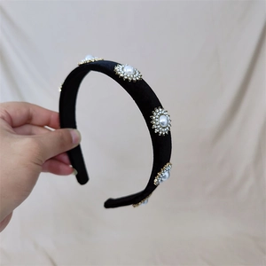 Détail du serre-tête en velours noir orné d'élégantes fleurs en perles et strass brillants