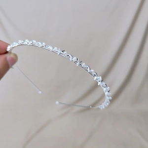 Detail view of thin silver headband with pearls and star-moon charms