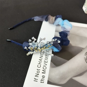 Detail of blue organza headband featuring handcrafted crystal branch and pleated texture