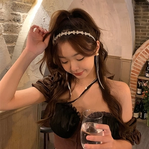 Sparkling rhinestone bow headband with elegant long pearl tassel earrings on a fashion model