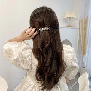Detail of floral crystal tassel hair clip with pearls worn by a model in casual setting