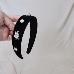 Gros plan détaillé du serre-tête en velours avec fleurs en perles et feuilles dorées