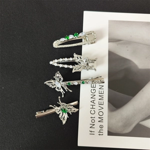 Detail view of 4-piece silver hair clip set with emerald green stones and butterfly motifs