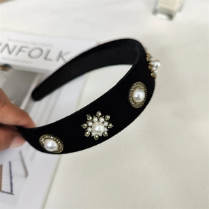 Détail d'un serre-tête baroque en velours noir avec perles vintage et strass brillants