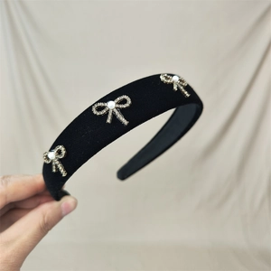 Close-up of black velvet headband with three elegant bows featuring pearls and rhinestones