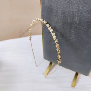 Vue détaillée du serre-tête en métal doré avec perles œil de chat et accents floraux