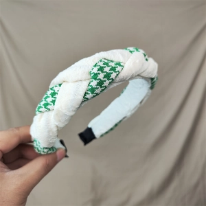 Detail of green houndstooth and beige fabric cross-knot headband with soft texture