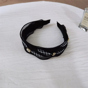 Detailed shot of houndstooth headband featuring ruffles and white crystal accents