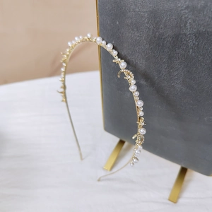 Détail du serre-tête en métal doré avec perles, strass et accents lune étoile