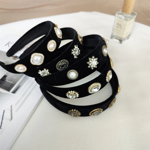 Serre-têtes baroques en velours noir avec perles et cristaux sur table chic