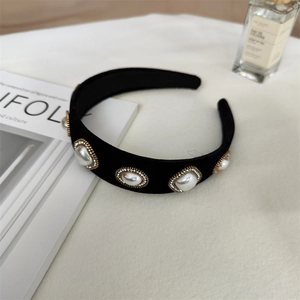 Détail du serre-tête en velours noir orné de cinq perles et de halos de strass étincelants