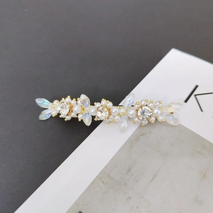 Detail shot of golden flower hair clip with sparkling crystals and white pearls