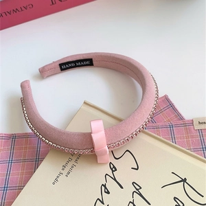 Detail view of pink bow headband with sparkling rhinestones and handmade inner tag