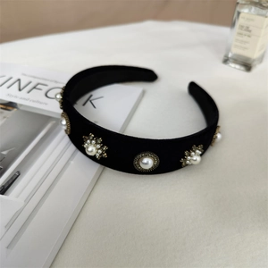 Gros plan d'un serre-tête en velours noir avec perles vintage et strass brillants