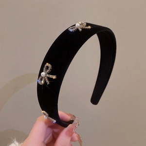 Elegant black velvet headband with three sparkling rhinestone bows and faux pearl accents