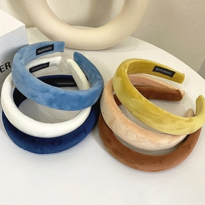 Detailed view of padded velvet headbands in assorted colors with handmade label