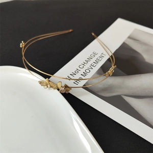 Detail of a golden double-layer metal headband with delicate 3D butterfly ornaments