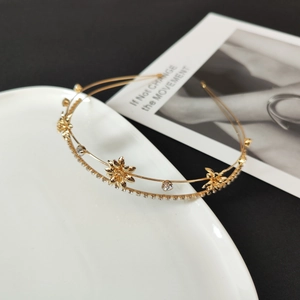 Detailed macro view of double-layered gold floral headband with zircon and rhinestones