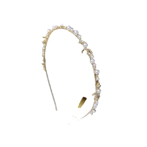 Serre-tête fin doré en métal avec perles et étoiles scintillantes sur fond blanc