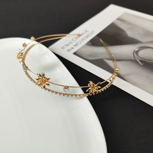 Close-up of double-layer golden headband with rhinestone flowers and zircon inlay