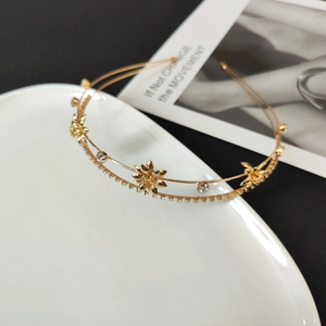 Detailed macro view of gold-layered headband with hollow zircon flowers and crystal rhinestones