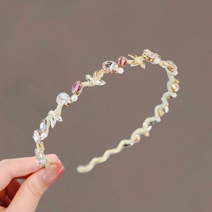 Cerchietto floreale con strass scintillanti e cristalli rosa su base dorata a onde