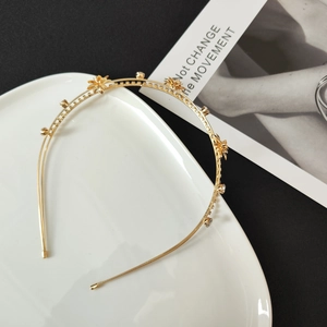 Detailed macro shot of golden flower headband with zircon rhinestones and hollow design