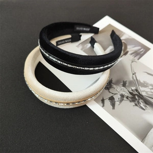 Detail showing sponge velvet headbands with rectangle rhinestones in black and off-white colors