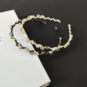 Dettaglio di cerchietti intrecciati con strass brillanti e perle eleganti