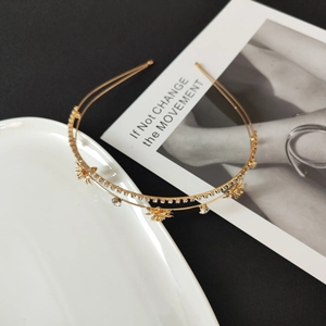 Macro view of golden double-layer headband with rhinestones and zircon floral pattern