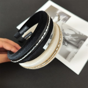 Close-up of handmade wide padded headband with rhinestone strip and satin finish texture