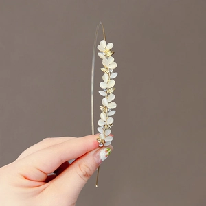 Elegant gold metal headband with white opal leaf accents and sparkling rhinestones