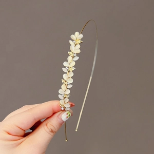 Golden metal headband featuring white cat eye stone leaves and sparkling rhinestones