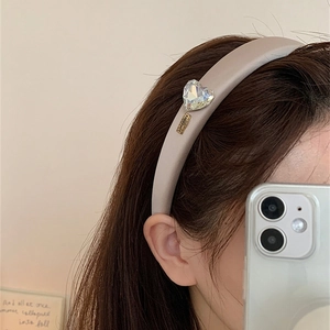 Détail du serre-tête en satin avec cœur en cristal et plaque métallique gravée