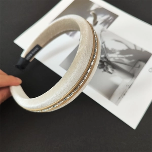 Detail of cream velvet headband with rectangular rhinestones and hand made label