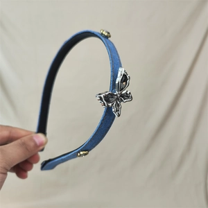 Denim headband featuring a silver metal butterfly ornament with grey crystals